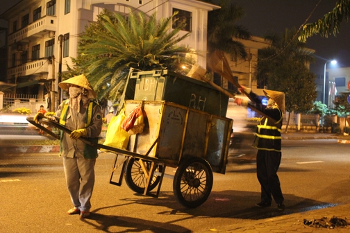 Anh chị em lao công làm việc trên đường Phạm Văn Đồng trong đêm giao thừa.