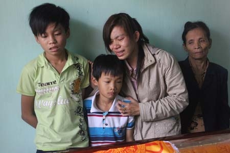 Hai đứa con trai của chị Đặng Thị Thơm cùng người thân đau xót bên quan tài của chị