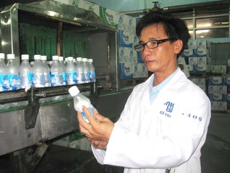 Kỹ sư Ngô Văn Khuê kiểm tra sản phẩm nước khoáng có ga trong chai pet.