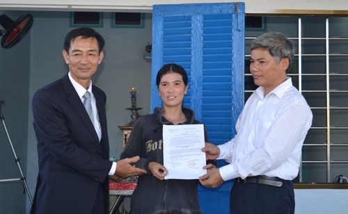 Đại diện Công ty Prudential Việt Nam và lãnh đạo báo Quảng Ngãi trao quyết định hỗ trợ nhà tình thương cho gia đình bà Trương Thị Lành