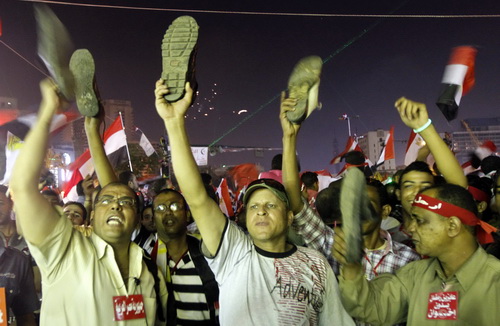  Người biểu tình vẫy giày khi nghe bài phát biểu trên truyền hình của Tổng thống Mursi - Ảnh: Reuters