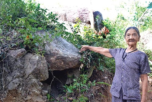 Cụ Nguyễn Thị Màng bên dấu tích miệng hầm từng nuôi giấu cán bộ thời kháng chiến chống Mỹ.