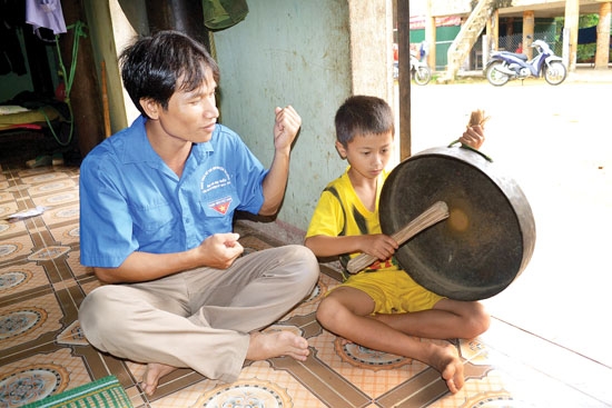 Anh Hồ Văn Vinh dạy con trai đánh chiêng.