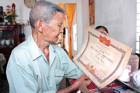         Bá Sơn Cựu chiến binh Nguyễn Ngoạn xem lại “Huy chương chiến thắng hạng nhất” do Đại tướng Võ Nguyên Giáp ký tặng năm 1958.  