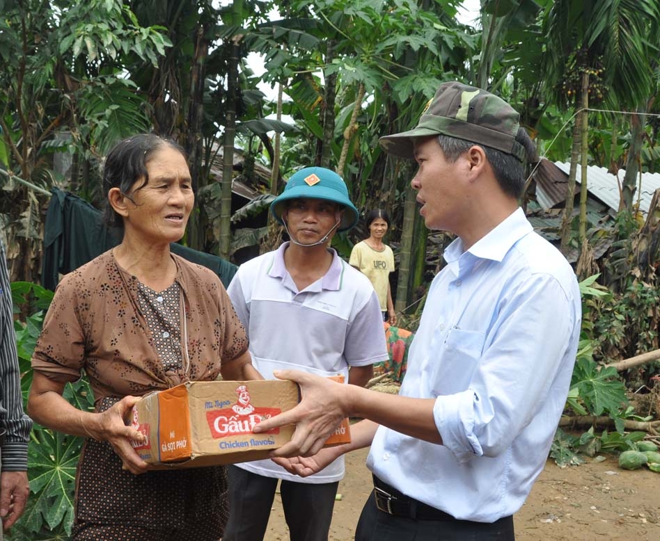 Bí thư Tỉnh ủy Võ Văn Thưởng trao mì gói và nước uống cho người dân vùng lũ.
