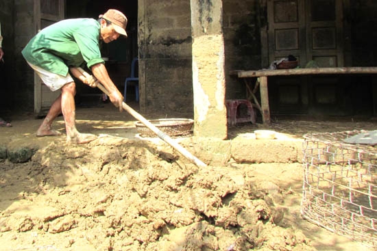 Người dân vất vả khi xử lý lớp bùn đất đặc quánh.