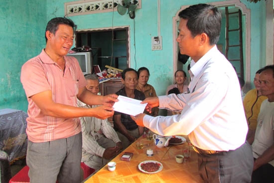 Chủ tịch UBND huyện Tư Nghĩa đến viếng và trao tiền hỗ trợ cho gia đình em Võ Văn Hợp.