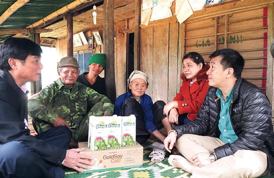 Đại diện Công ty Vinamilk và  Tiến sĩ Trần Quang Trung - Cục trưởng Cục An toàn vệ sinh thực phẩm (trái) đến thăm hỏi, tặng quà cho người dân xã Ba Điền (Ba Tơ).