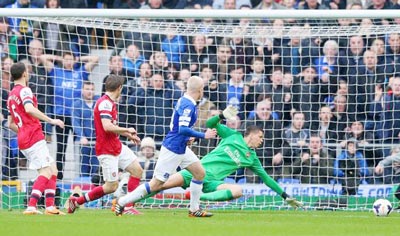 Steven Naismith (áo xanh) sút tung lưới thủ môn Wojciech Szczesny mở tỷ số 1 - 0 cho Everton.