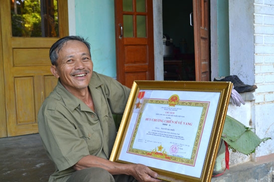 Ông Thịnh tự hào bên Huy chương Chiến sĩ Vẻ vang của người con trai lớn Nguyễn Bá Chiểu.