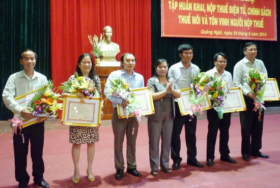 Phó Chủ tịch UBND tỉnh Đinh Thị Loan trao bằng khen của Bộ Tài chính cho các doanh nghiệp tiêu biểu trong việc thực hiện nghĩa vụ thuế năm 2013. Ảnh: H.TRIỀU