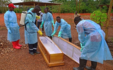 Nhân viên y tế khử trùng quan tài dùng để mai táng bệnh nhân Ebola ở châu Phi (ảnh: AFP)