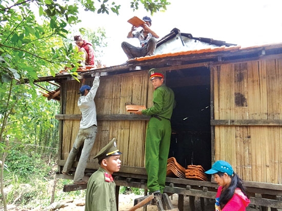 Cán bộ, chiến sĩ Công an huyện Sơn Tây giúp dân di dời nhà khỏi lòng hồ thủy điện Đăkđrinh.