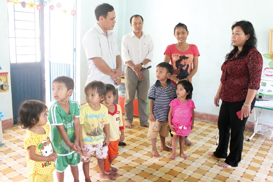 Phó Chủ tịch UBND tỉnh Đinh Thị Loan (bên phải) và lãnh đạo huyện Trà Bồng thăm hỏi việc học tập của con em vùng tái định cư thuộc dự án thủy điện Hà Nang.