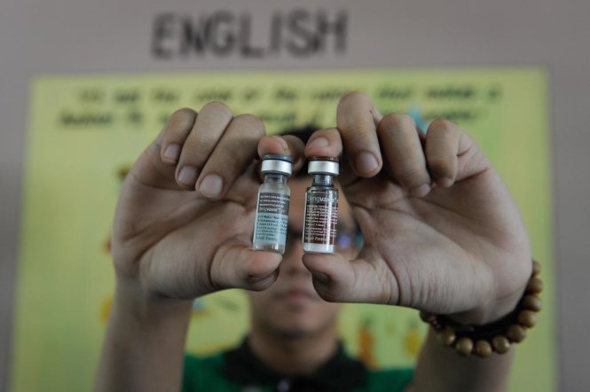  Một nhân viên y tế cầm hai lọ văcxin Dengvaxia, văcxin phòng sốt xuất huyết đầu tiên trên thế giới, tại Manila ngày 4-4-2016 - Ảnh: Getty Images