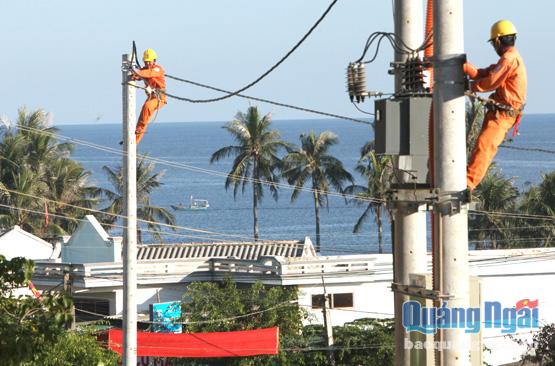 Công nhân điện lực Quảng Ngãi hoàn thiện hệ thống lưới điện ở xã An Bình (Lý Sơn). Ảnh: PV