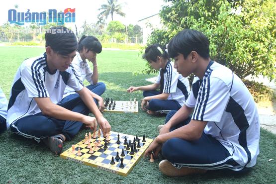 Giờ giải lao, Quang (bên trái) cùng các bạn tìm niềm vui trong bàn cờ vua.