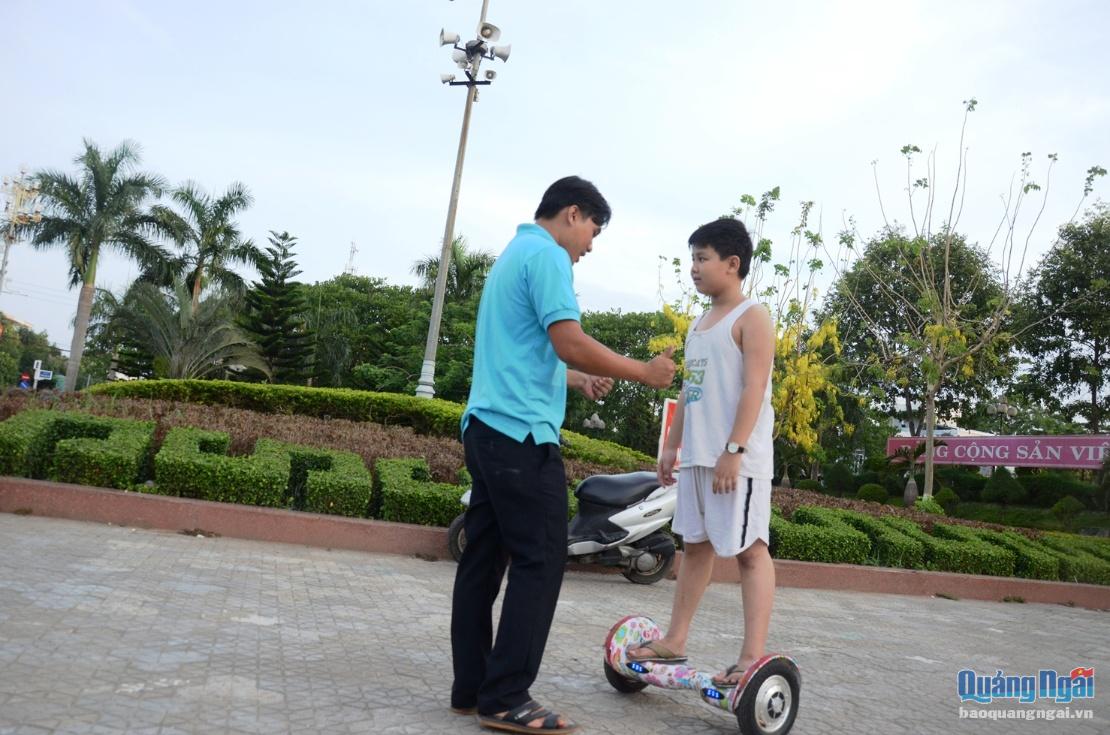 Anh Võ Duy Thịnh là người đầu tiên cho thuê loại xe này từ dịp lễ 30.4. Hiện nay ở khu vực quảng trường có 3 người cho thuê xe với giá 50-80 nghìn đồng/ giờ tùy theo loại. Trong ảnh là anh Nguyễn Hữu Anh Dương đang hướng dẫn cho một bạn nhỏ học cách chơi xe cân bằng.