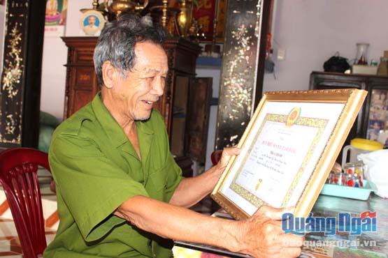 Ông Trần Chánh rạng rỡ bên tấm bằng khen do Đảng và Nhà nước trao tặng.