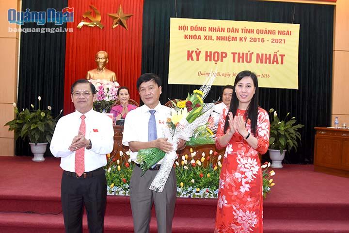 Đồng chí Lê Viết Chữ và đồng chí Bùi Thị Quyền Vân tặng hoa chúc mừng đồng chí Trần Ngọc Căng
