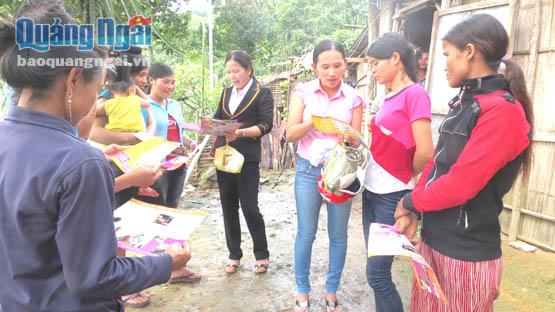  Cán bộ dân số huyện Tây Trà phát tờ rơi tuyên truyền cho chị em phụ nữ đồng bào Cor.