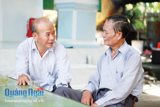 Ông Nhung (bên trái) đang bàn bạc vấn đề của thôn với hội viên Hội Cựu chiến binh của thôn An Hòa.