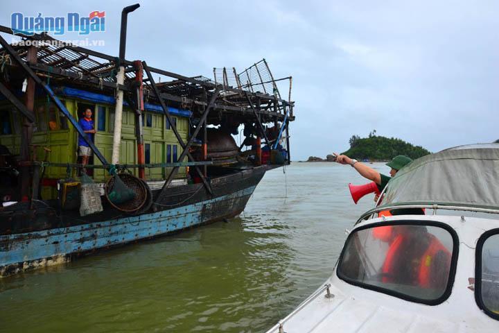 Cán bộ Đồn Biên Phòng Bình Đông kiểm tra và hướng dẫn tàu thuyền của ngư dân neo đậu an toàn.
