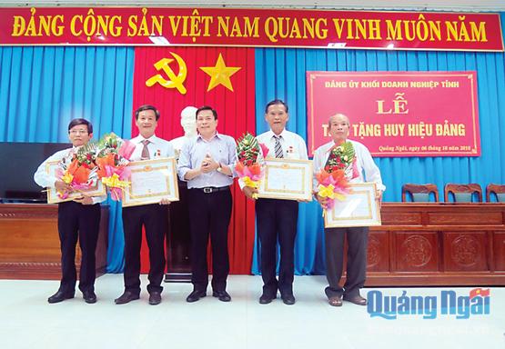 Phó Bí thư Tỉnh ủy Trần Văn Minh (đứng giữa) trao Huy hiệu 30 năm tuổi đảng cho các đảng viên thuộc Đảng ủy Khối Doanh nghiệp.