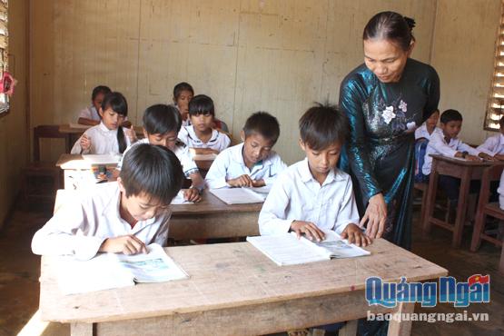 Cô giáo tiểu học vùng cao xã Ba Dinh ân cần hướng dẫn các em trong học tập.