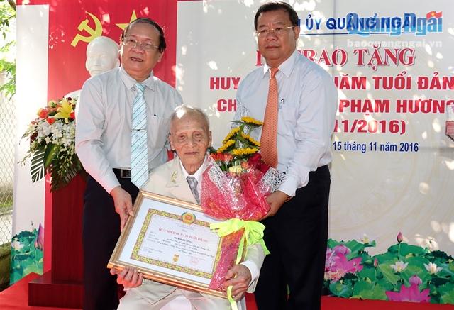 Phó Bí thư Thường trực Tỉnh ủy Nguyễn Thanh Quang ( bên trái) và Bí thư Thành ủy Nguyễn Tăng Bính trao Huy hiệu 80 năm tuổi Đảng cho đồng chí Phạm Hương
