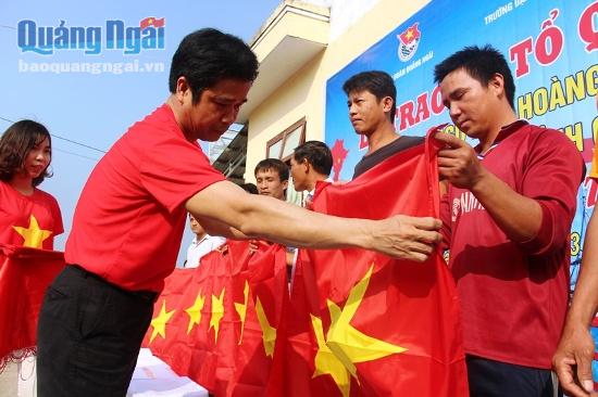 Đại diện Trường Đại học sư phạm Huế trao cờ tổ quốc cho ngư dân Lý Sơn.