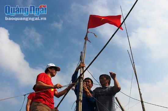 Đại diện Tỉnh Đoàn cùng Trường Đại học sư phạm Huế gắn cờ tổ quốc trên thuyền ngư dân.