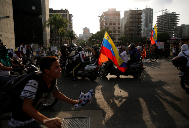 Người biểu tình xung đột với cảnh sát chống bạo loạn tại Caracas, Venezuela ngày 19-4 - Ảnh: Reuters