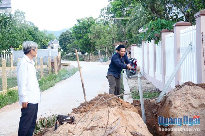  Cán bộ thôn Nho Lâm, xã Phổ Hòa (Đức Phổ) kiểm tra việc thi công công trình “Điện thắp sáng đường quê” do nhân dân đóng góp kinh phí.                 Ảnh: PV