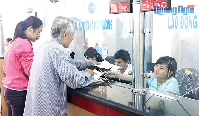Cán bộ Bộ phận một cửa huyện Bình Sơn giải quyết thủ tục hành chính cho dân.