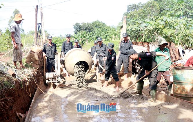 Cán bộ, chiến sĩ Tiểu đoàn 3, Trung đoàn CSCĐ Nam Trung Bộ giúp người dân thôn Vạn Tường  bê tông xi măng đường giao thông.