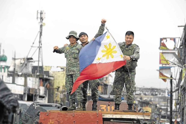 Binh sĩ Philippines vẫy cờ ăn mừng chiến thắng tại Marawi (Ảnh: AFP)