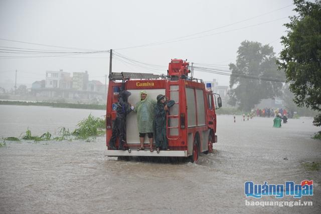 Lực lượng cảnh sát pccc huy động xe thang để chở người dân và phương tiện đi qua các nơi bị nước lũ chia cắt
