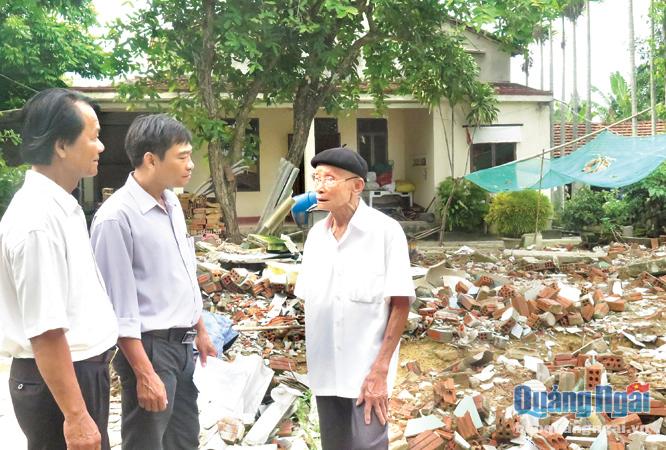 Anh Xuân (đứng giữa) thăm hỏi hộ gia đình ở thôn Phước Hòa, nơi phải thực hiện di dời.
