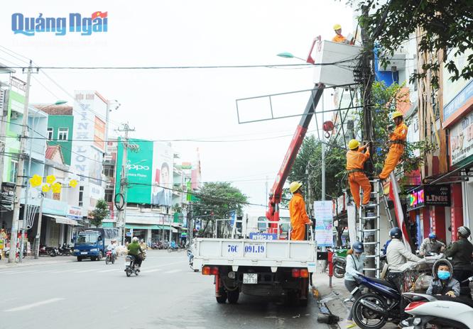 Công nhân điện lực TP.Quảng Ngãi đang khắc phục sự cố chập điện trên đường Lê Trung Đình.