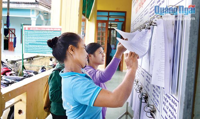 Người dân xã Sơn Dung đọc hướng dẫn về các bước làm thủ tục liên quan đến giấy tờ.