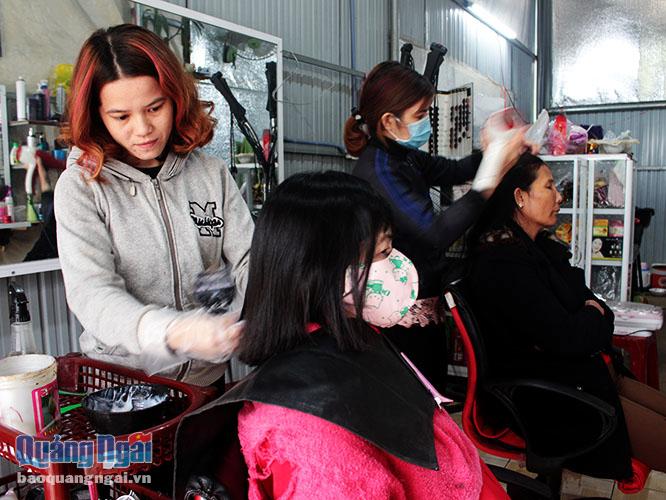 Khách hàng đang được chăm sóc tóc tại một của tiệm bình dân.