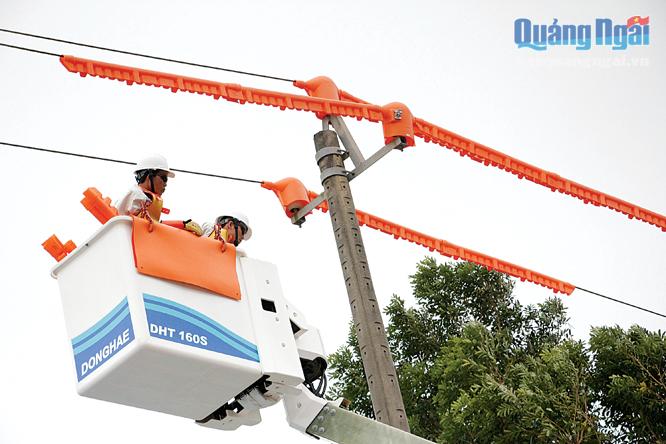 Đội sửa chữa Hotline Công ty Điện lực Quảng Ngãi thay sứ cách điện đứng trên đường dây 22kV đang mang điện tại KCN Tịnh Phong.