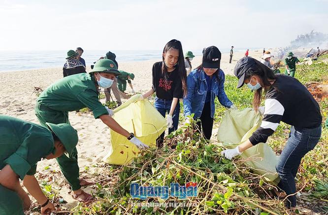 Cán bộ, chiến sĩ BĐBP tỉnh phối hợp với đoàn thanh niên địa phương thu gom rác thải ở bờ biển thôn Tân An, xã Nghĩa An (TP.Quảng Ngãi) trong tháng Thanh niên 2018.                                                               