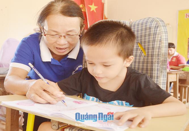   Cô giáo Nguyễn Thị Liên Minh tận tình hướng dẫn học trò Phạm Nhất Duy tập viết.