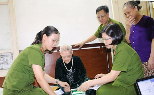 Bà Phạm Thị Cúc (giữa) khi được lực lượng công an đến nhà riêng làm CMND mới vào tháng 7-2015- Ảnh: ANTĐ