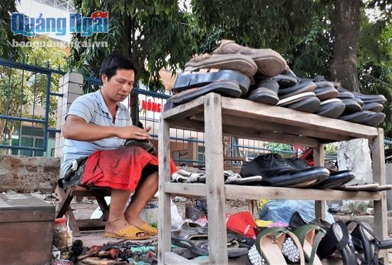 Anh Đinh Văn Đại vẫn miệt miệt sửa giày để kịp trả khách.