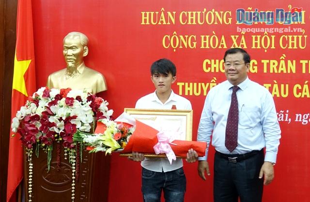 Thừa ủy quyền của Chủ tịch nước, Phó Chủ tịch Thường trực UBND tỉnh Nguyễn Tăng Bính trao Huân chương Dũng cảm cho ngư dân Trần Thanh Ron