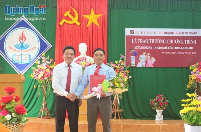 Đại diện Agribank Quảng Ngãi trao giải Khuyến khích cho khách hàng Trần Đức Vinh. 