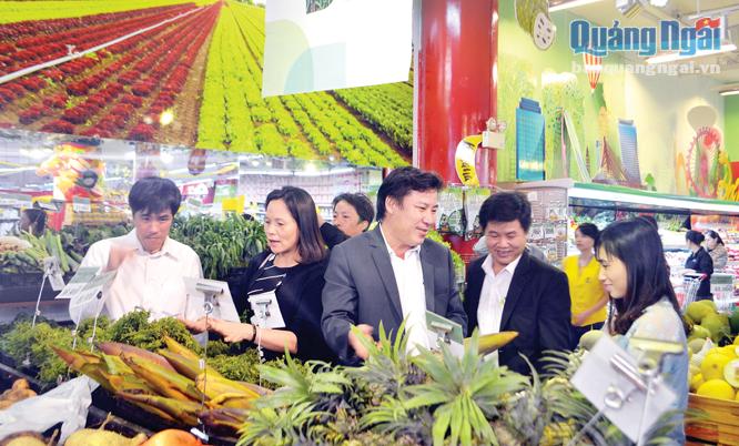 Ông Phùng Tô Long (thứ 3 từ trái sang) và lãnh đạo huyện Sơn Hà giới thiệu sản phẩm của địa phương đến với người tiêu dùng tại siêu thị.    
